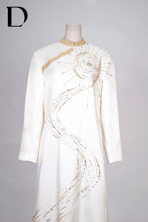 Đỗ Long giải thích về các họa tiết trên hai chiếc áo dài: "Hoa văn trống đồng được thêu bằng chỉ ánh kim trên viền cổ tay áo đến con đường chữ S đi về hướng mặt trời. Đôi Thiên Nga thêu đính 3D trên nền mặt trăng mặt trời được lồng ghép với nhau mang ý nghĩa về một tình yêu vĩnh cửu, đầy viên mãn". Ảnh: FB Đỗ Long.