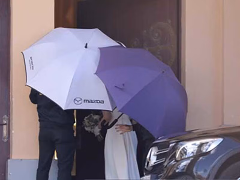 Trong hôn lễ, ca sĩ Tóc Tiên được che chắn bằng ô khi mặc váy trắng bước vào nhà thờ. Ảnh: Thời Đại Plus.