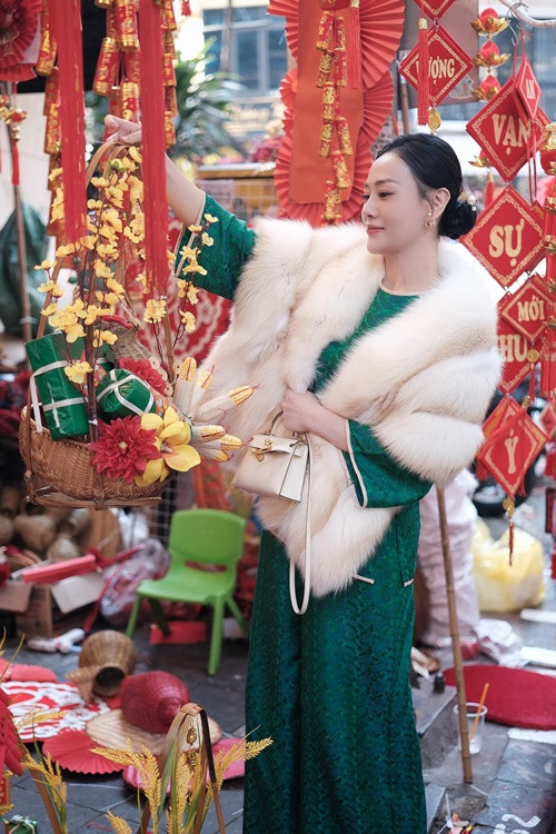Nữ diễn viên lựa chọn đồ trang trí Tết trên phố Hàng Mã. Phương Oanh cho biết, cô đã mua hai chú lợn đất để hai con đựng tiền tiết kiệm. Ảnh: FB Phương Oanh.