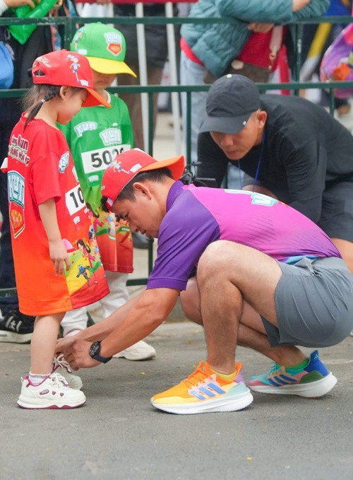 Nam nghệ sĩ hài còn được khán giả yêu mến qua những hình ảnh thân thiện ở đời thường. Trong ảnh, nghệ sĩ Xuân Bắc chỉnh giày cho một em bé khi cả hai tham gia một giải chạy bộ. Ảnh: FB Xuân Bắc.