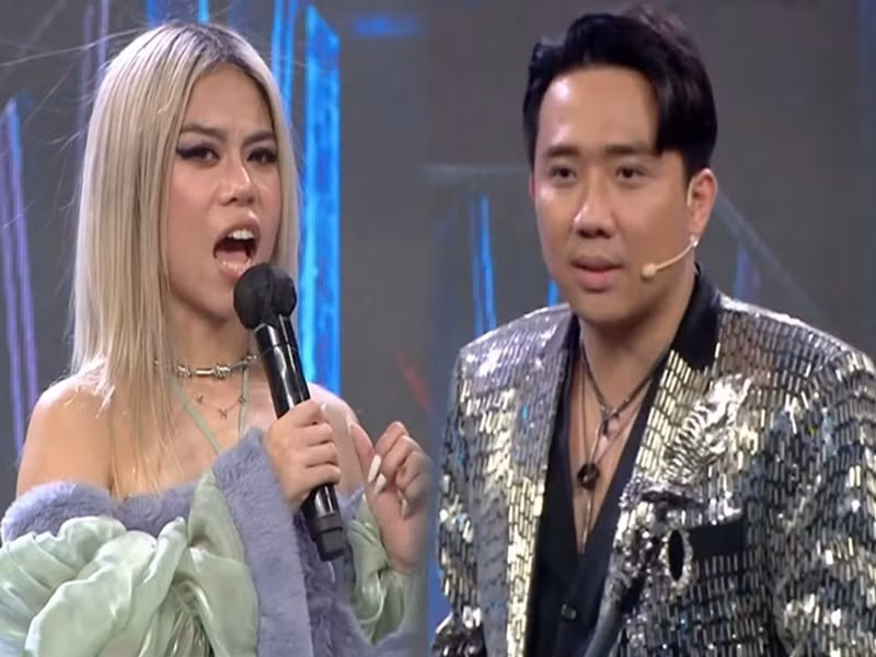 Trong chung kết Rap Việt tháng 1/2022, nghe Tlinh hát Gái độc thân, Trấn Thành đặt một câu hỏi khá nhạy cảm: "Em hát bài này là chỉ hát vậy thôi hay đang độc thân?". Không muốn lên tiếng về chuyện tình cảm sau khi chia tay MCK, Tlinh trả lời: "Anh có thể nào đặt một câu hỏi khác tinh tế hơn được không?". Trấn Thành đổi câu hỏi nhưng không khác gì câu trước: "Hiện em có độc thân không?". Cuối cùng, Trấn Thành cũng đổi sang một câu hỏi khác. Ảnh: Doanh Nghiệp Tiếp Thị.