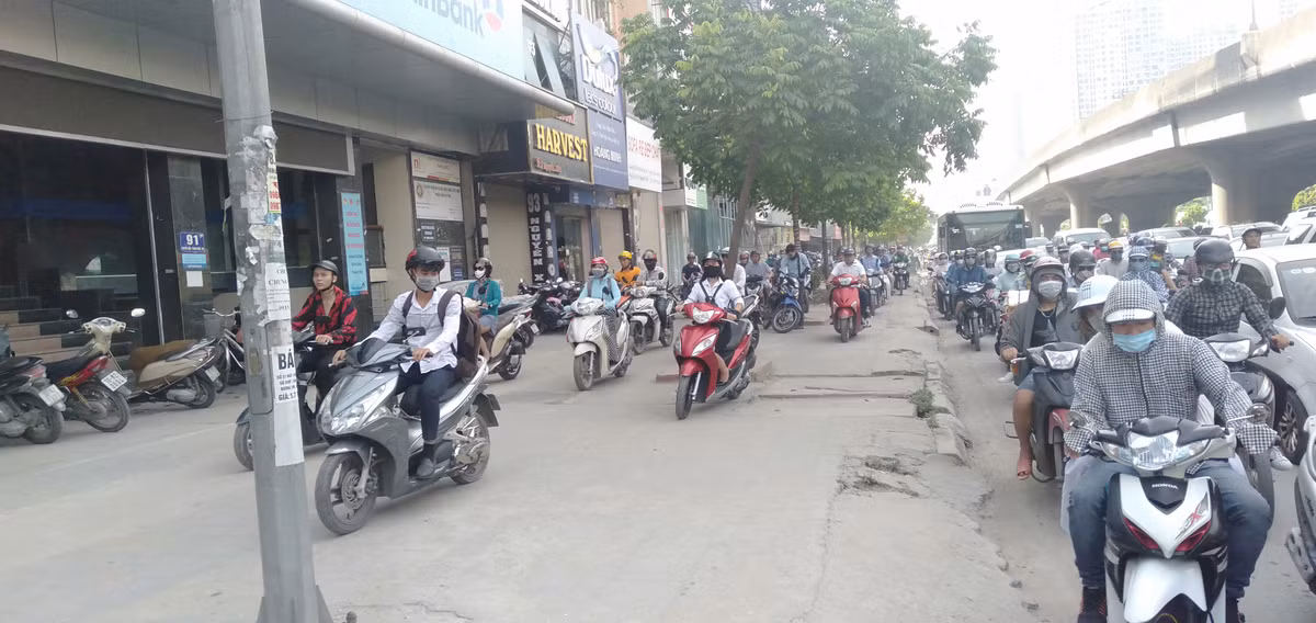 Xe máy tràn lên cả vỉa hè nhằm thoát khỏi đám đông kẹt cứng.