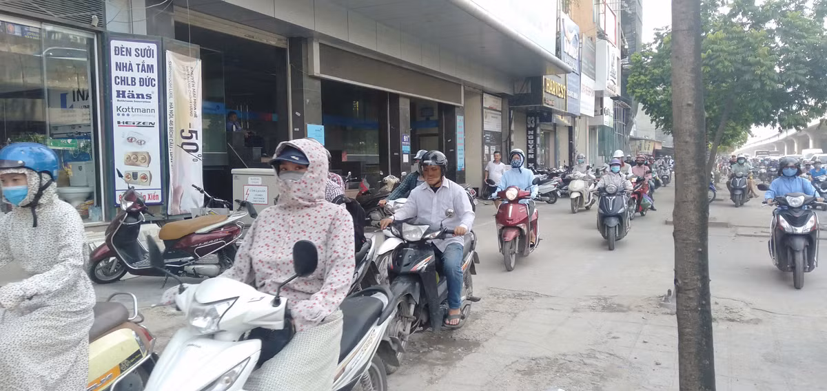 7h30 sáng nhưng nắng đã khá gắt, nhiều người mặc áo chống nắng, đi lên vỉa hè để tránh nắng.