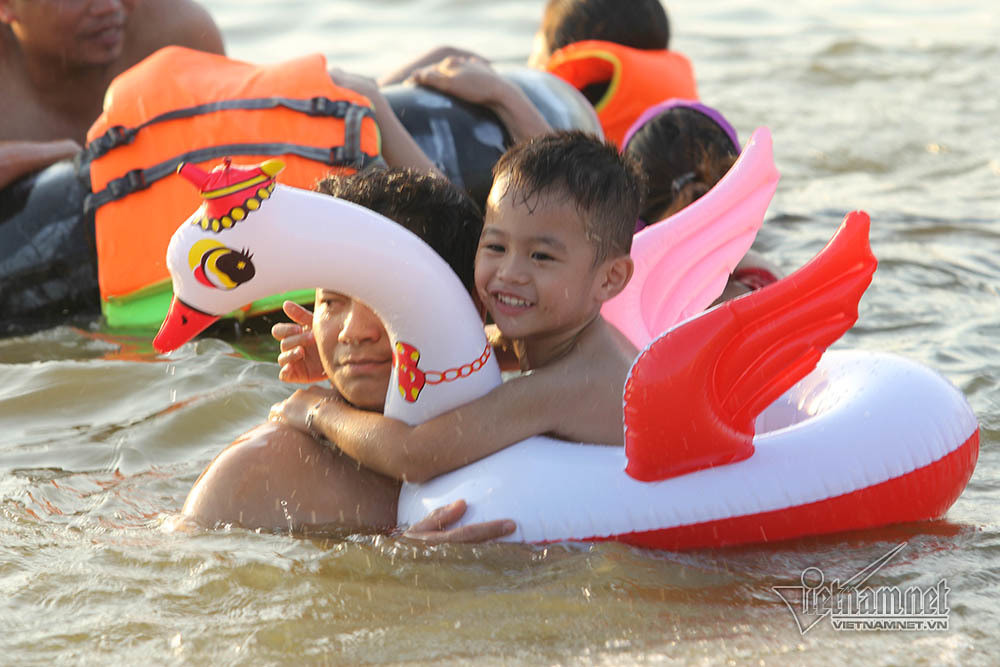 Nhiều ông bố cho con ngồi lên phao để đưa ra xa bờ