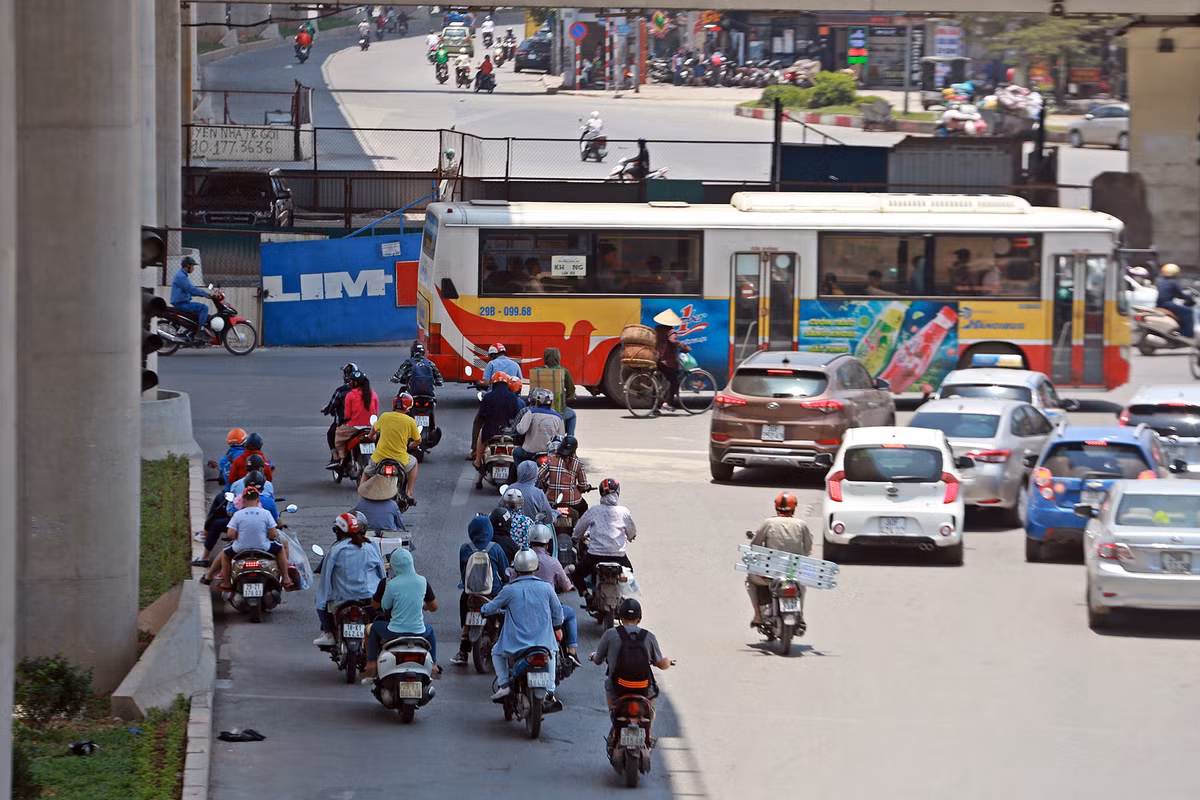 Trong lúc chờ đèn đỏ, nhiều phương tiện đi xe máy "trú ẩn" dưới bóng mát của chân đường sắt Nhổn - ga Hà Nội (đoạn cầu Mai Dịch).