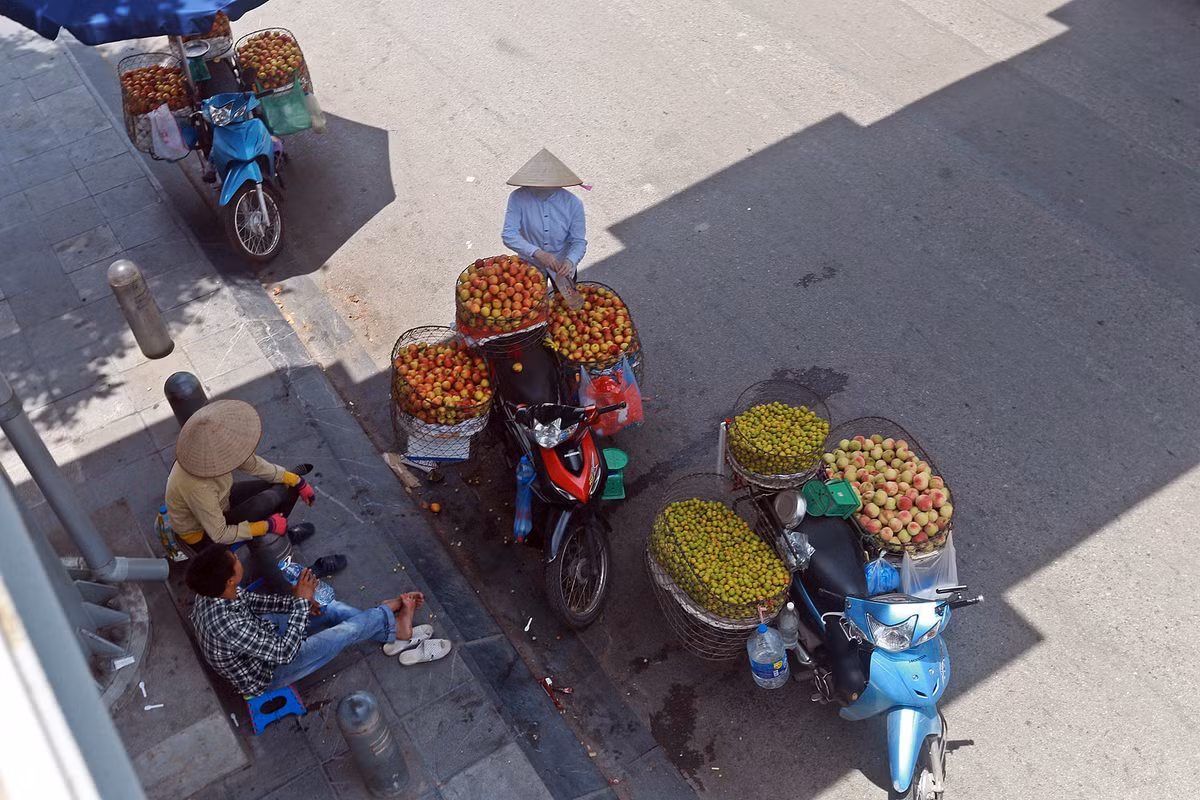 Những người bán hàng rong cũng tận dụng bóng mát ở một gầm cầu vượt đi bộ bắc ngang qua đường sắt Cát Linh - Hà Đông để nghỉ ngơi và bán hàng.