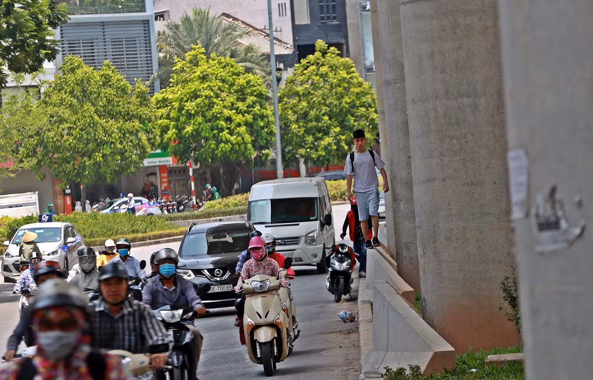 Trên đường Cầu Giấy, một thanh niên đi bộ dưới chân đường sắt Nhổn - ga Hà Nội, phía ngoài trời nắng như đổ lửa.