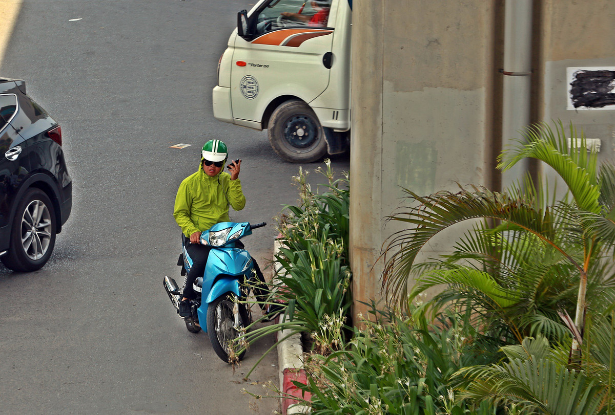 Một thanh niên tận dụng bóng mát của đường sắt Cát Linh - Hà Đông để dừng xe nghe điện thoại (đoạn đường Nguyễn Trãi).