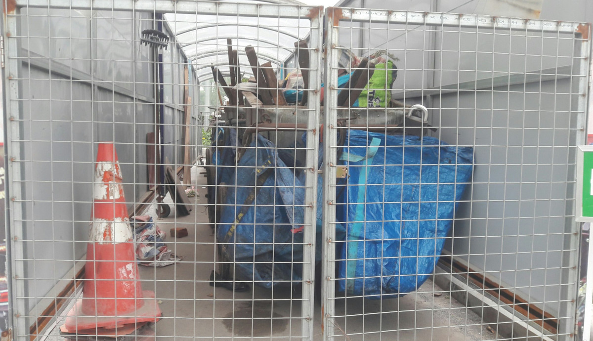 Các dụng cụ dọn rác được các lao công sắp xếp gọn gàng trong nhà chờ gom rác di động và được khoá lại.