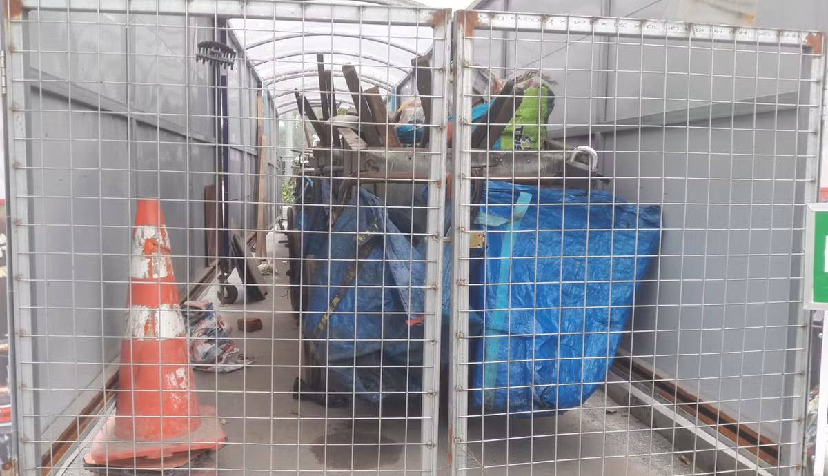 Các dụng cụ dọn rác được các lao công sắp xếp gọn gàng trong nhà chờ gom rác di động và được khoá lại.