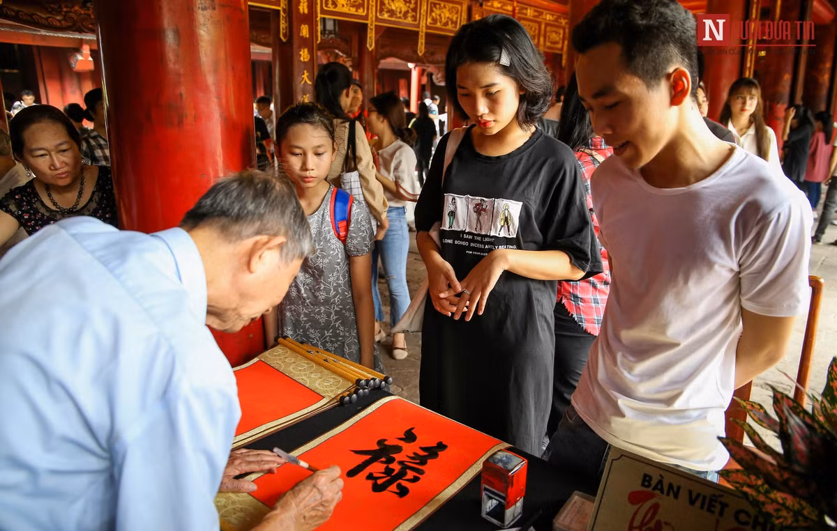 Rất nhiều phụ huynh và thí sinh sau khi lễ xong còn xin chữ về treo trong nhà để tiếp thêm động lực cho các em trong thi cử. (Ảnh: Người đưa tin)