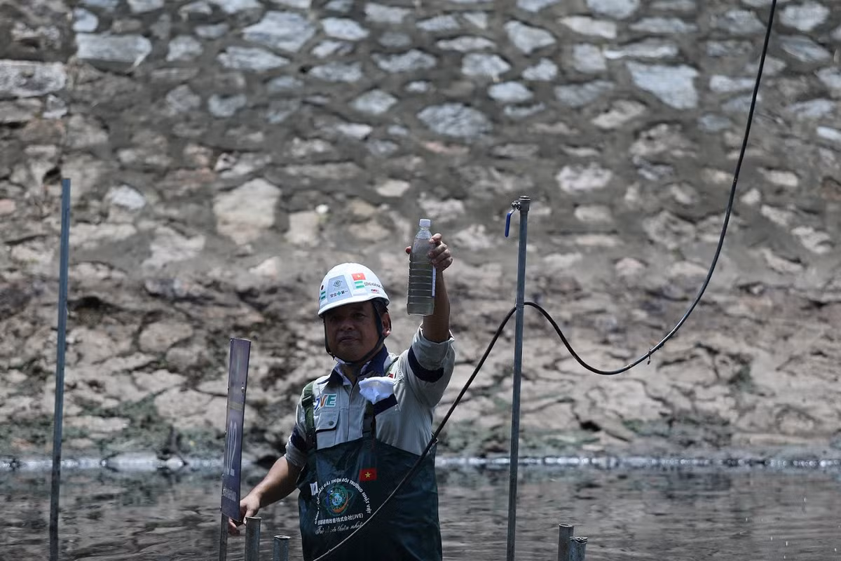 TS Kubo Jun giơ chai nước được lấy tại vị trí đặt máy trên sông Tô Lịch.