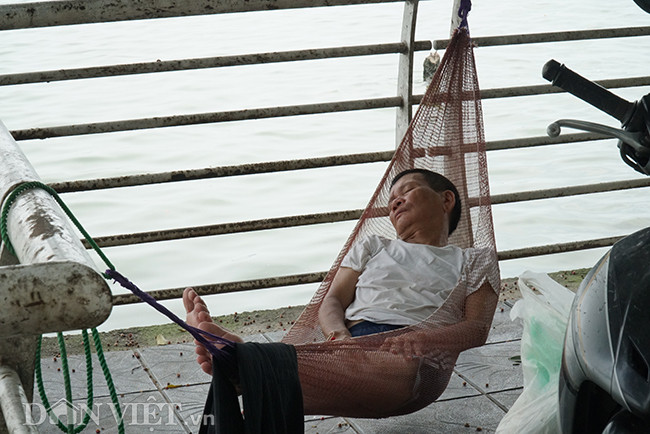 Một tài xế xe ôm công nghệ mắc võng nghỉ trưa ngay trên vỉa hè Hồ Tây.