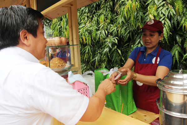 Ông Đoàn Ngọc Hải tặng quà may mắn cho tiểu thương phố hàng rong sau khi quận 1 (TP HCM) khai trương phố hàng rong thứ hai trong công viên Bách Tùng Diệp, phường Bến Nghé.