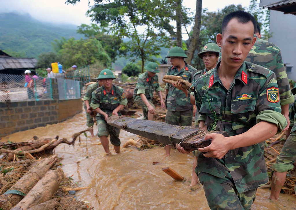 Cán bộ chiến sĩ Sư đoàn 316, Quân khu 2 giúp dân dọn dẹp lại bản làng sau lũ ống tại Bản Tủ, Văn Chấn, Yên Bái tháng 7/2018. Ảnh: Hoàng Anh.