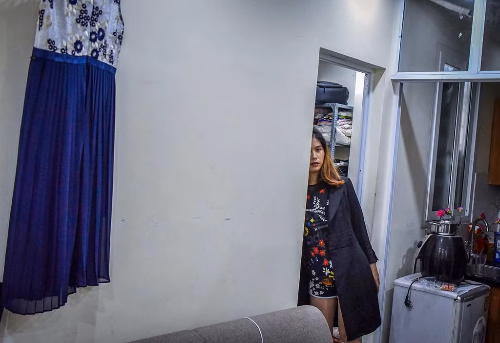 Lê Quốc Phong (31 tuổi) trong căn phòng trọ của mình ở Hà Nội. Năm 2012, Phong đã quyết định phẫu thuật để chuyển giới tính từ nam sang nữ. Dù phải đánh đổi hàng chục năm tuổi thọ cùng vô vàn bất tiện trong sinh hoạt nhưng đó là quyết định mà cô không bao giờ hối hận bởi giờ đây Phong được thoải mái sống thực với giới tính của mình. Ảnh: Việt Linh.