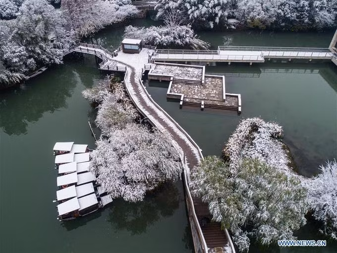 Tuyết đầu mùa mới chỉ đủ phủ một lớp "áo trắng" lên vạn vật cây cỏ, những chiếc thuyền nan nhưng chưa đủ để khiến dòng kênh đóng băng lạnh lẽo. Mặt nước xanh thẫm đối lập với khung cảnh tuyết trắng xoá.