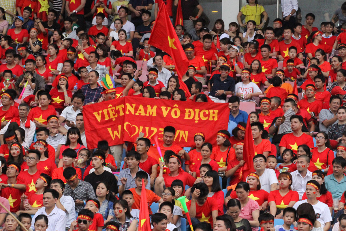 Những CĐV giơ cao những lá cờ như một lời chào đón đoàn thể thao Việt Nam, một lời cảm ơn về sự nỗ lực cố gắng của các VĐV để mang lại vinh quang cho nước nhà