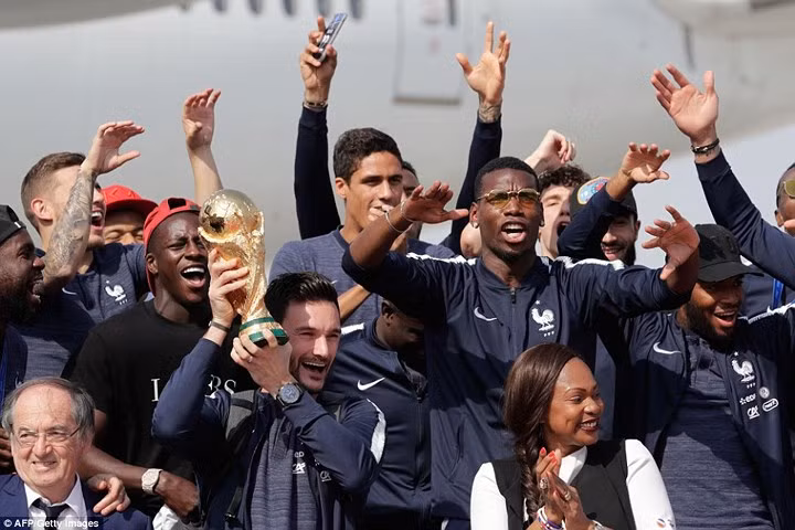 Paul Pogba và các đồng đội ăn mừng trước các phóng viên có mặt ở sân bay Charles de Gaulle.