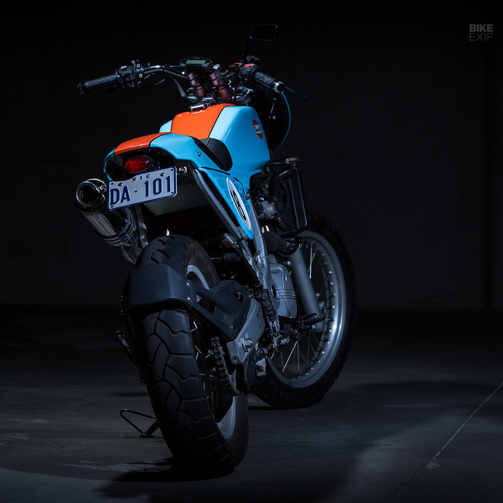 Nối bình xăng và phần đuôi là tấm ốp kim loại lấy cảm hứng từ các mẫu địa hình. Mọi thứ đều được gắn trên phần khung nguyên bản. Yên xe được thay đệm và tạo hình lại bởi người vợ của Andrew. Ảnh: Bike EXIF