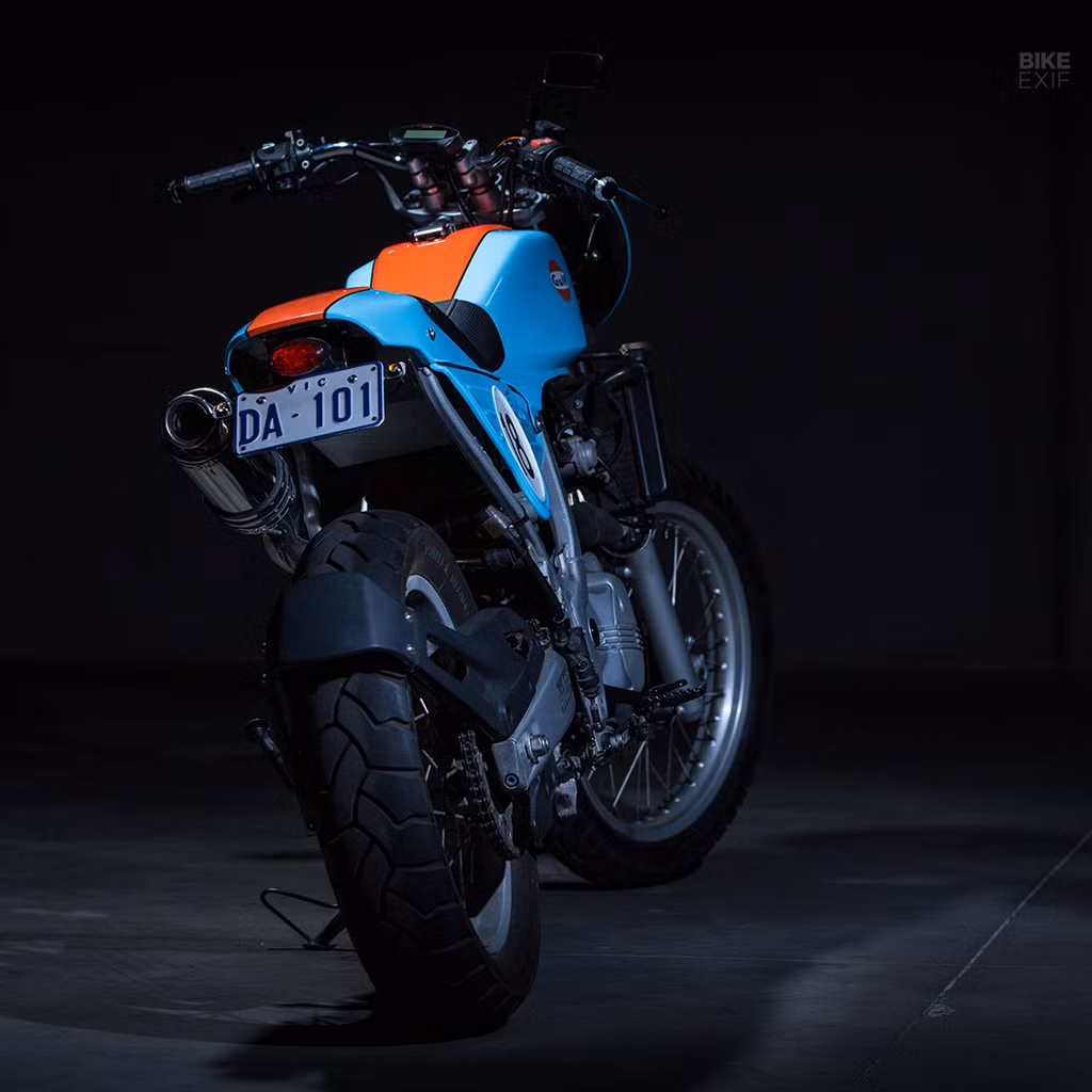 Nối bình xăng và phần đuôi là tấm ốp kim loại lấy cảm hứng từ các mẫu địa hình. Mọi thứ đều được gắn trên phần khung nguyên bản. Yên xe được thay đệm và tạo hình lại bởi người vợ của Andrew. Ảnh: Bike EXIF