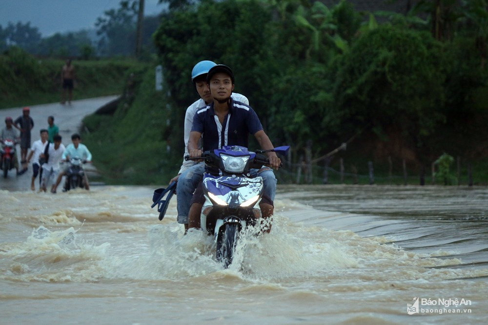 Sau những cơn mưa to, đập tràn cạnh bản Hoa Tiến 1 biến thành dòng sông lớn, nước lũ chảy cuồn cuộn gây trở ngại cho người và phương tiện qua lại. Mỗi ngày, cư dân ở hai bản Hoa Tiến 1 và Hoa Tiến 2 với tổng cộng 371 hộ phải qua lại trên con đập này. Ảnh: Hữu Vi