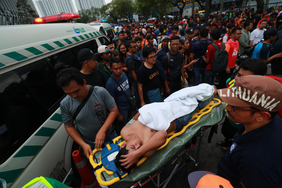 Nam thanh niên được đưa lên cáng cứu thương sau khi ngất xỉu - Ảnh: Nguyễn Khánh