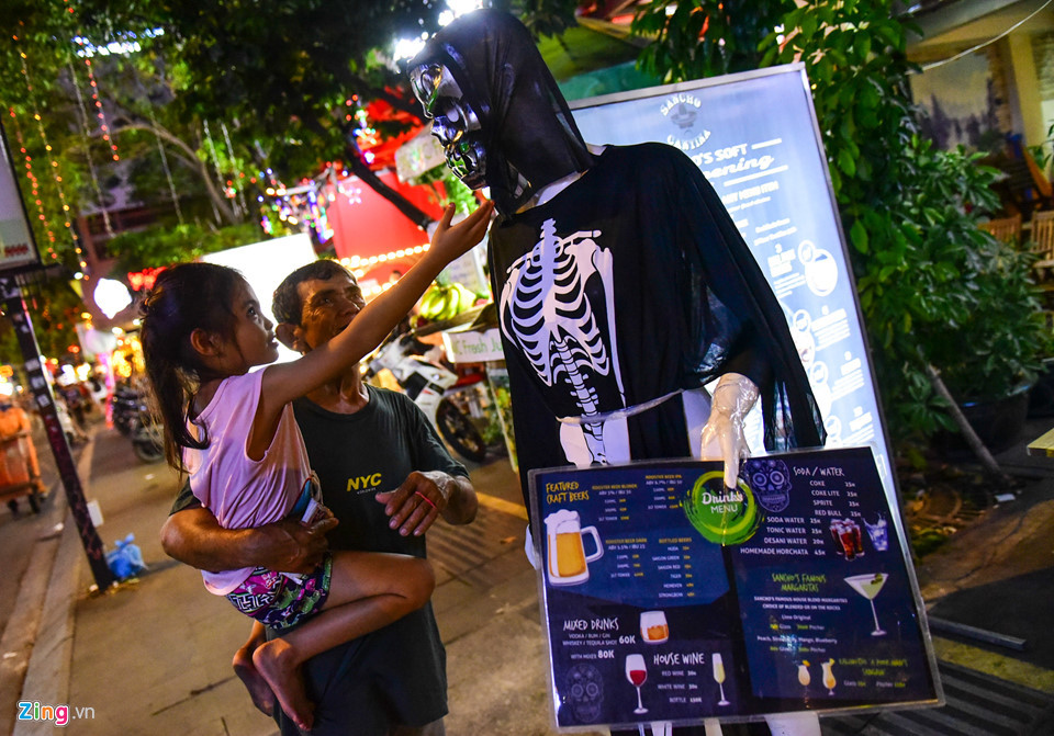 Hai ông cháu dạo quanh phố Bùi Viện. Khi gặp những nhân vật được hoá trang, cô bé tỏ ra rất tò mò, thích thú.