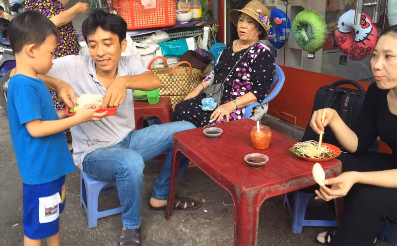 Cậu bé bê đồ ăn cho khách.