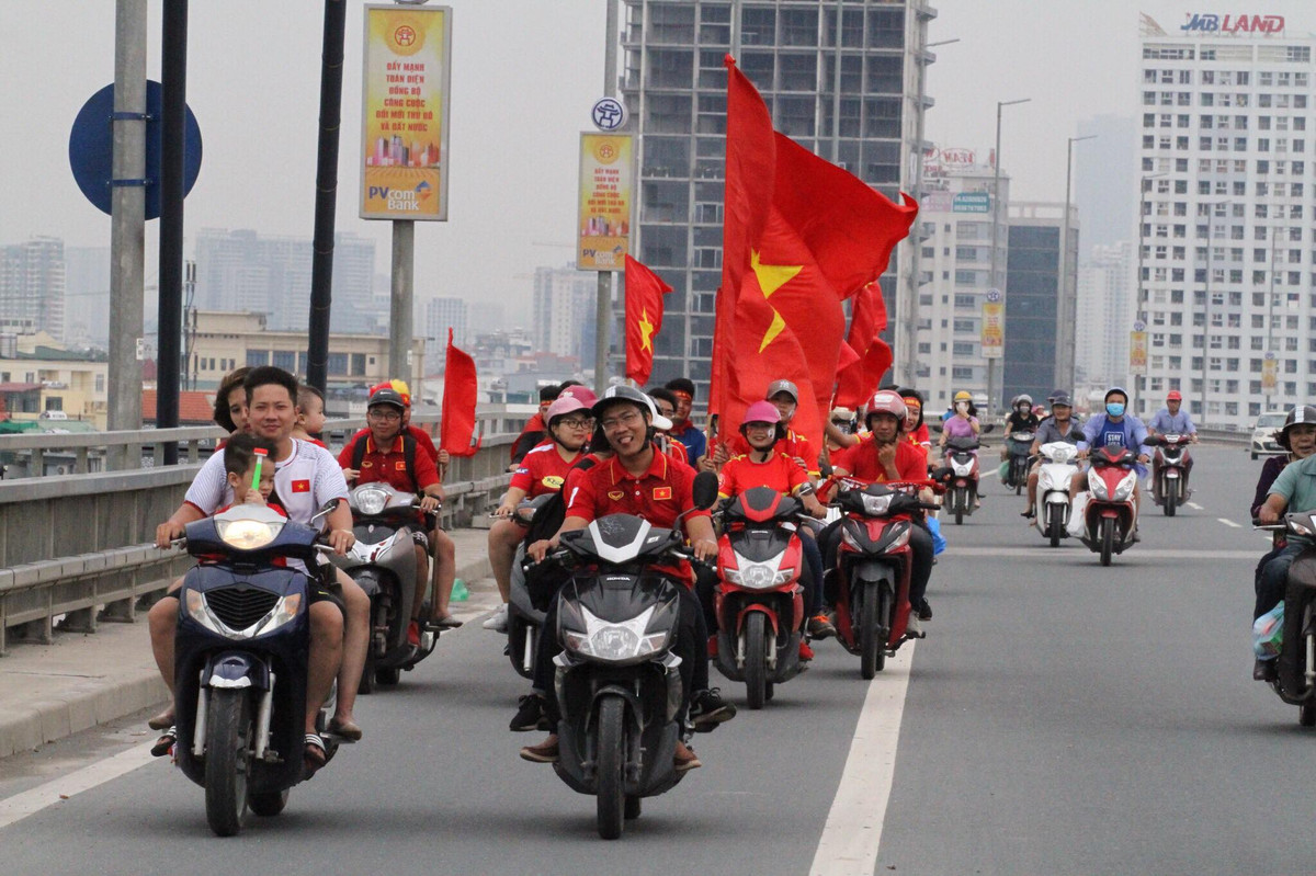 Dọc tuyến đường ra sân bay Nội Bài rực rỡ hơn trong ngày Quốc Khánh 2/9, hàng trăm người dân tại Thủ đô Hà Nội đã chuẩn bị sẵn sàng áo đỏ sao vàng, cờ hoa, khẩu hiệu đứng tại các tuyến đường đội tuyển Olympic Việt Nam sẽ đi qua.