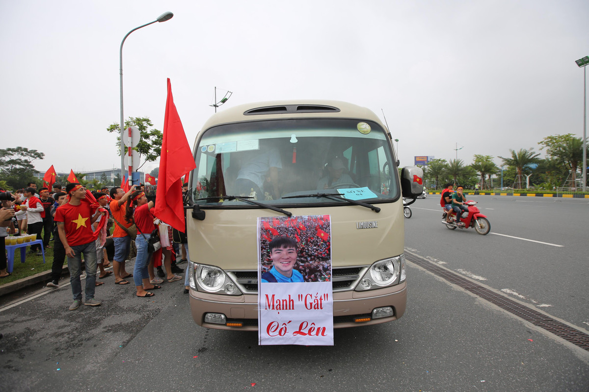 Không chỉ có gia đình cầu thủ Quang Hải và Đức Huy, xe ô tô 29 chỗ chở gia đình cầu thủ Duy Mạnh cũng đã có mặt tại cổng sân bay Nội Bài, trước xe có treo băng rôn "Mạnh gắt cố lên".