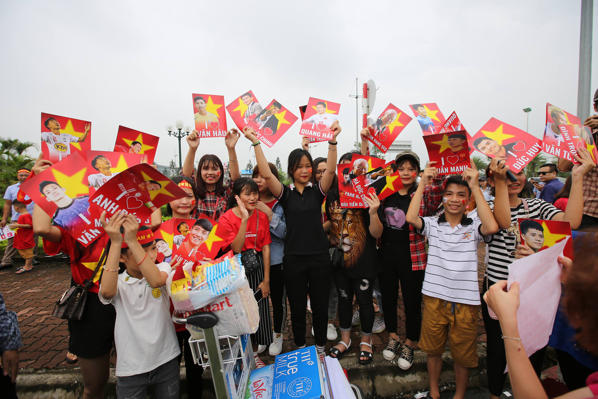 Tại khu vực gần cổng sân bay Nội Bài, số lượng người hâm mộ đổ về đây mỗi lúc một đông, không khí vô cùng tưng bừng, náo nhiệt.