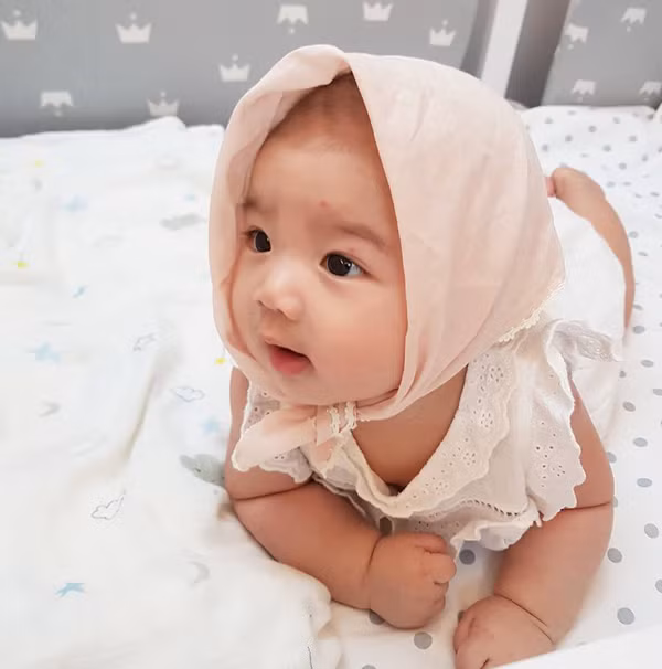 Trong ảnh, thiên thần nhỏ được mẹ Linh diện cho váy trắng, đầu đội khăn. Cô công chúa bé nhỏ sở hữu làn da trắng hồng và gương mặt bầu bĩnh, vô cùng đáng yêu.