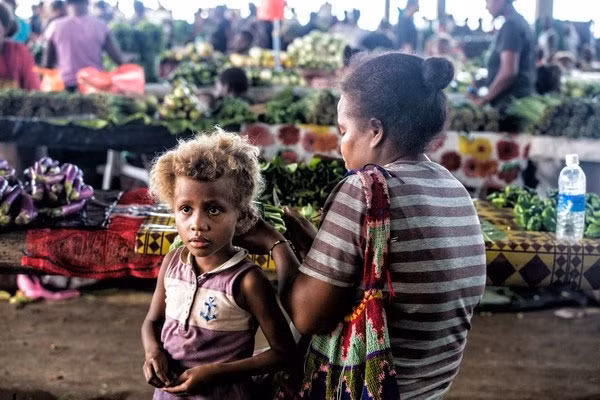 Bé gái cùng mẹ tới chợ mua đồ đang ngồi nghỉ chân. Ảnh Sina