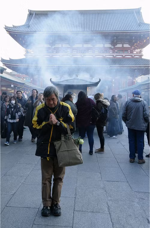 Người đàn ông thành tâm cầu khấn tại đền thiêng này. Ảnh Sina