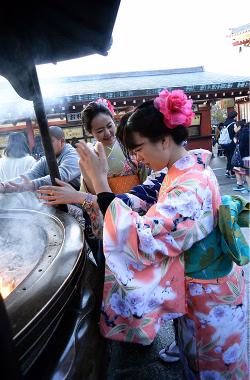 Các thiếu nữ Nhật Bản mặc kimono thành tâm cầu khấn khi tới đền Sensoji. Đây là hình ảnh mà các du khách Trung Quốc ghi lại được tại một trong những ngôi đền linh thiêng và cổ nhất ở Tokyo trong những ngày đầu xuân năm mới. Ảnh Sina