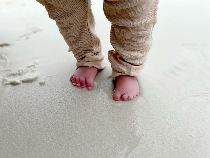 “Lần đầu tiên trong đời bàn chân con chạm lên cát và nước biển”, Quý Bình viết.