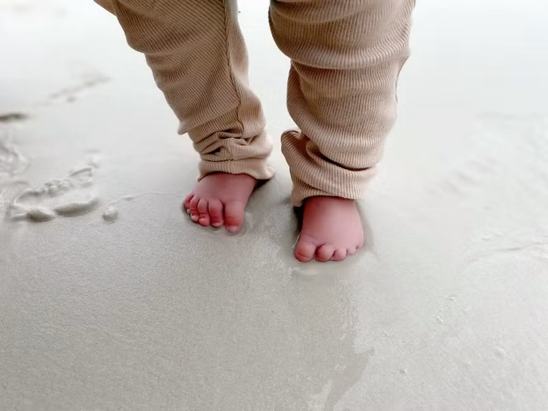 “Lần đầu tiên trong đời bàn chân con chạm lên cát và nước biển”, Quý Bình viết.