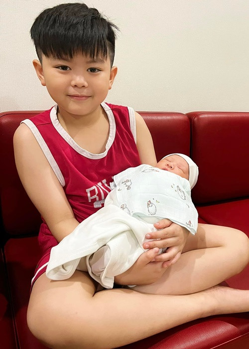 Tuấn Tú chia sẻ hình ảnh con trai đầu lòng bế em bé mới sinh.
