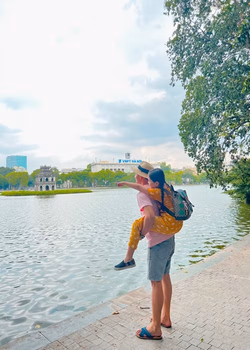 Lý Bình cõng con gái riêng của vợ trong chuyến du lịch ở Hà Nội.