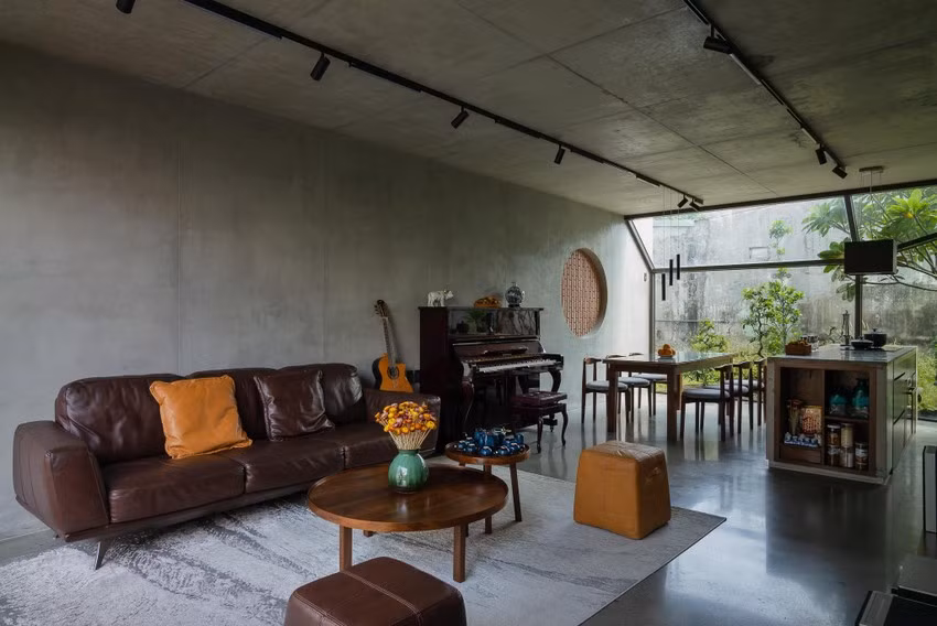 Chiếc ghế sofa, bàn tròn trên tấm thảm rộng làm nổi bật không gian phòng khách.