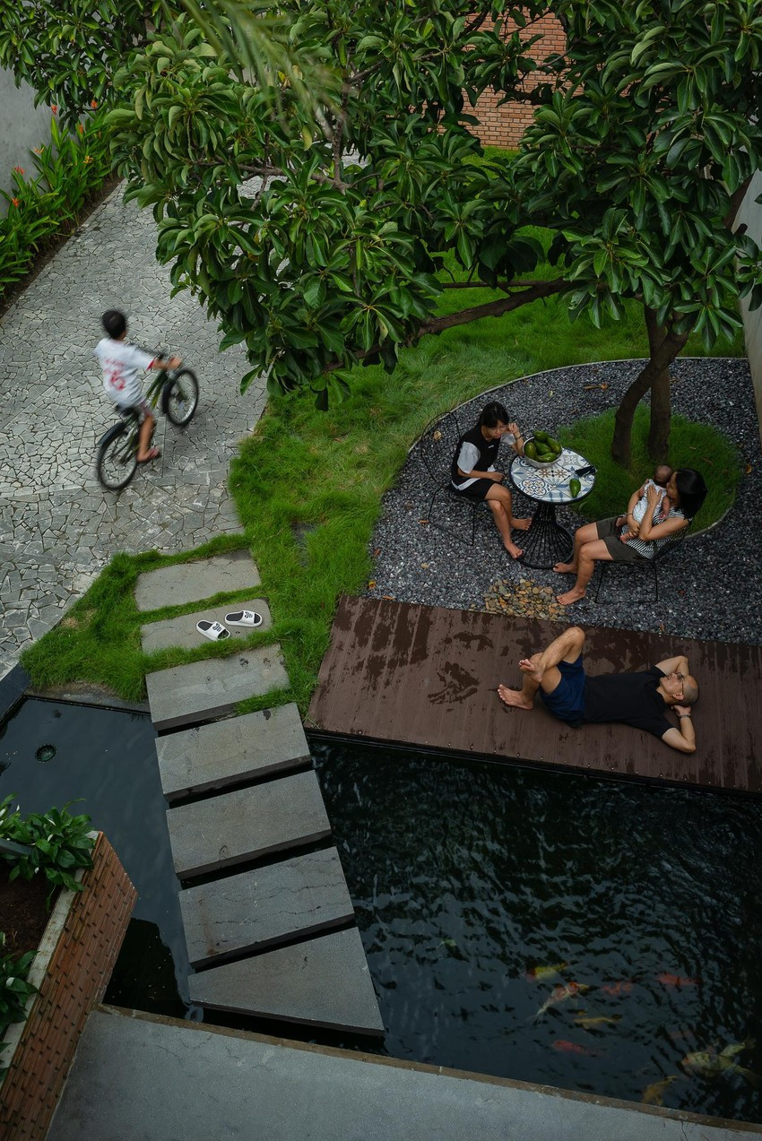 Bể nước nuôi cá và chiếc bàn nhỏ xinh dưới tán cây lớn là nơi thư giãn, vui chơi của gia đình.