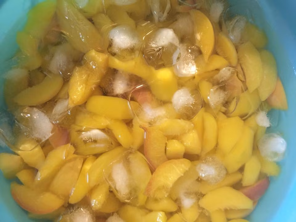 Bước 4: Vớt đào ra cho vào thau nước đá lạnh ngâm cho nguội. Bước này giúp đào giữ miếng đẹp và giòn hơn.