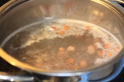 Trước tiên bạn lấy lạc tươi ra bóc vỏ cứng bên ngoài rồi cho vào nồi nấu chín với một chút nước lạnh. Nước phải ngập hết mặt lạc và đủ dùng. Bạn cứ đun tới khi lạc chín mềm rồi tắt bếp để đó.