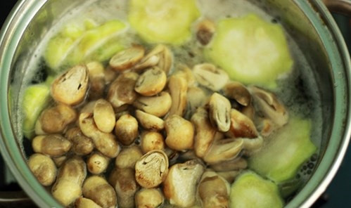 Đợi nước trong nồi đến khi sôi thì cho nấm rơm vào.