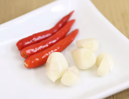 Ớt rửa sạch, cắt bỏ cuống. Tỏi bóc vỏ, có thể để nguyên tép hoặc thái lát mỏng tùy vào sở thích.