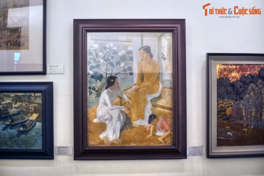 Tranh được vẽ năm 1944 bằng chất liệu sơn dầu trên vải toan, cao 102 cm, rộng 71,8 cm, tái hiện hình ảnh hai phụ nữ mặc áo dài ngồi tâm sự ngoài hiên nhà, bên cạnh có một bé trai đang ngồi chơi. Ba nhân vật được bố cục dạng tam giác tạo nên trạng thái tĩnh lặng, cân bằng, êm ả.