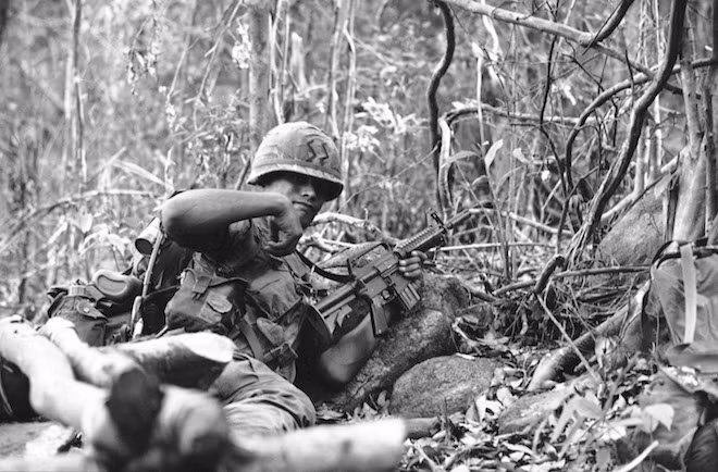 Lính nhảy dù Mỹ ra hiệu lệnh cho đồng đội di chuyển thành vành đai phòng thủ gần khu vực ở đông bắc Sài Gòn năm 1967.