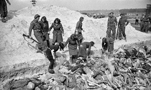 Nữ sĩ quan SS chất đống thi thể nạn nhân trong một ngôi mộ tập thể dưới sự giám sát của binh sĩ Anh tại trại Bergen-Belsen năm 1945.