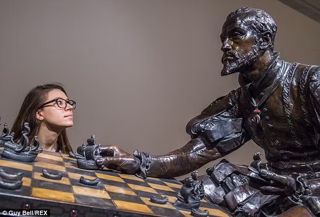 Nữ du khách chiêm ngưỡng bức tượng đồng Nữ hoàng Elizabeth I và Philip của Tây Ban Nha chơi cờ vua.